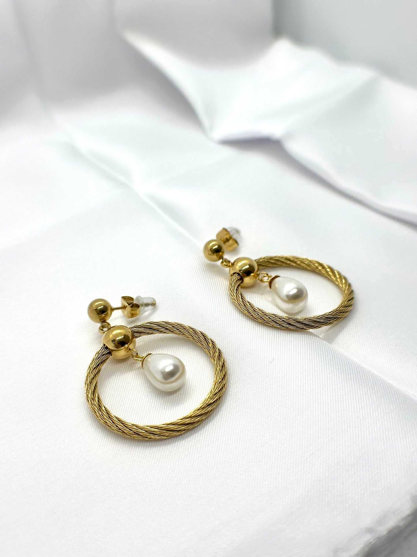 Boucles d’oreilles pendantes dorées torsadées avec perle blanche